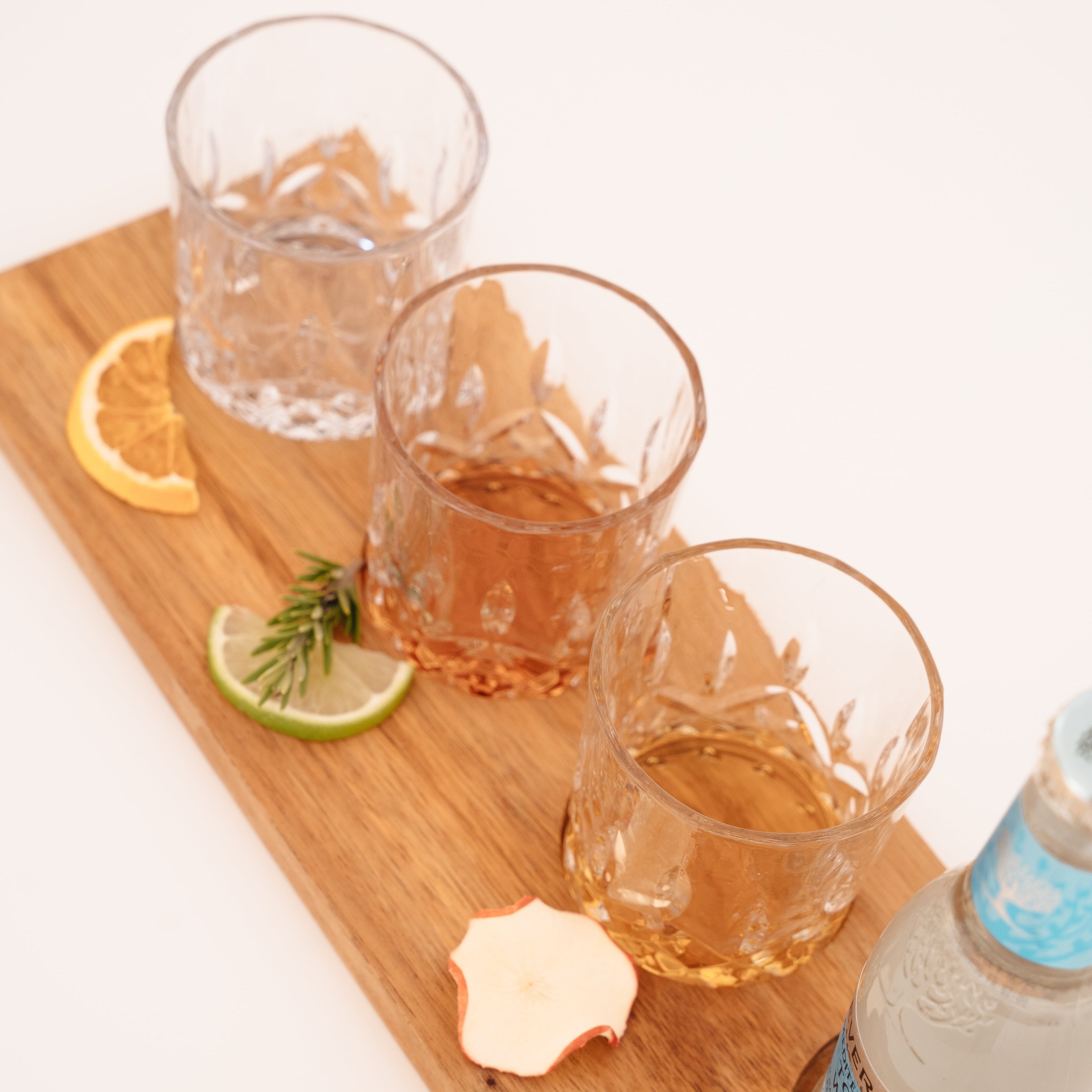 3 glasses on a wooden tasting flight board with Ginny Pig Gin