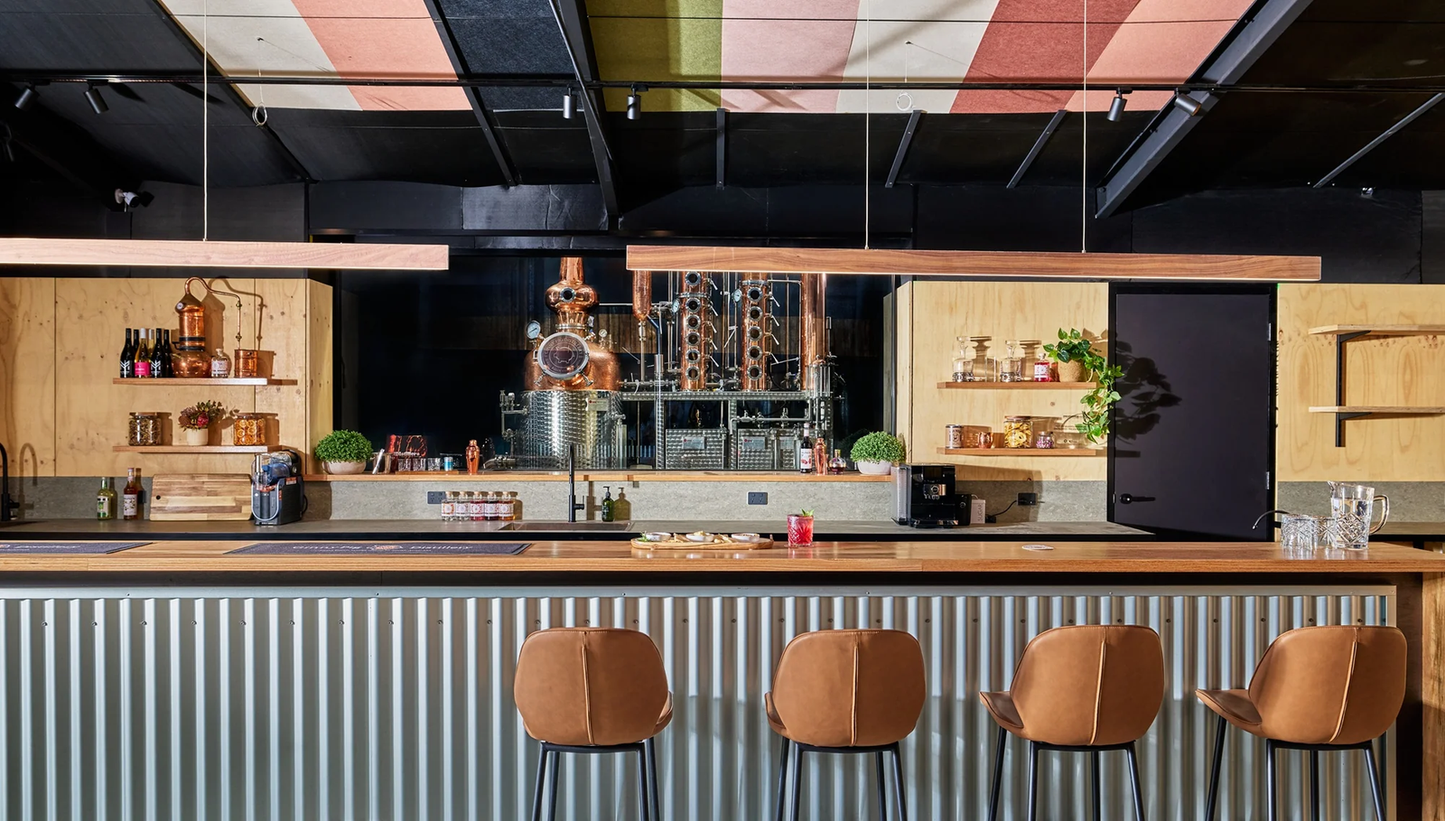 Modern bar with wooden counter, stools, and colorful ceiling