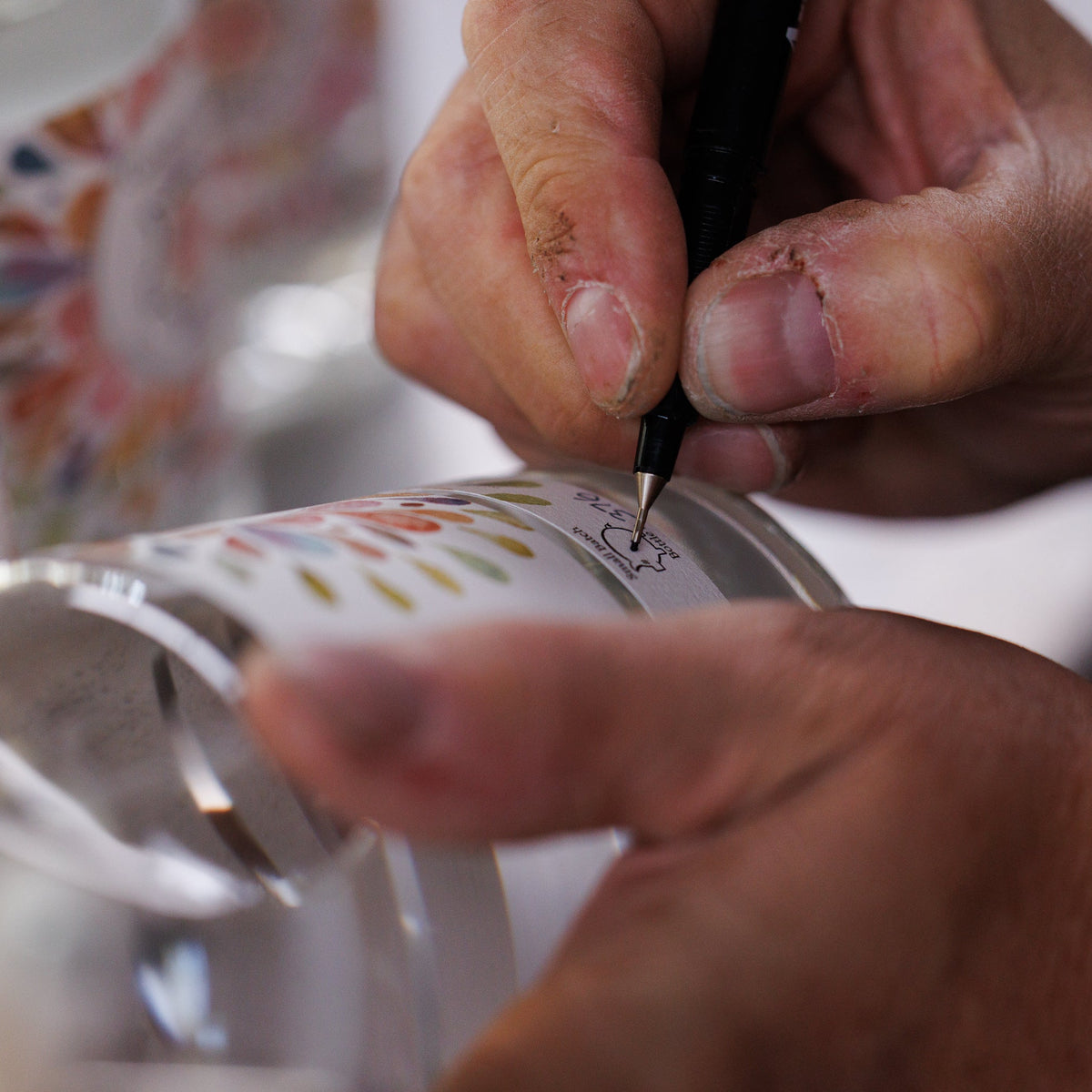 Person writing a number on a bottle